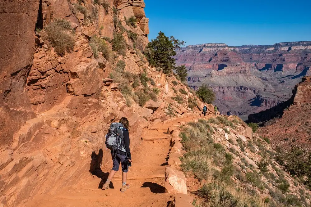 A hiker on a trail below the South Rim of the Grand Canyon