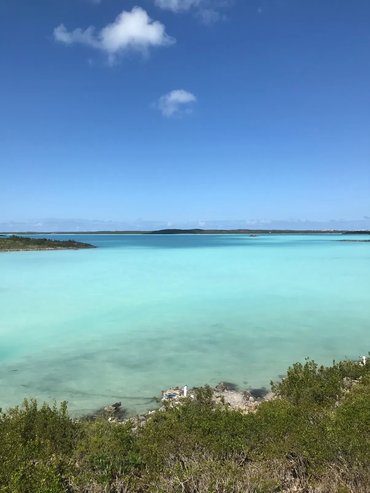 Chalk Sound, a vast milky-turquoise lagoon under a deep blue sky, seen from the shore lookout