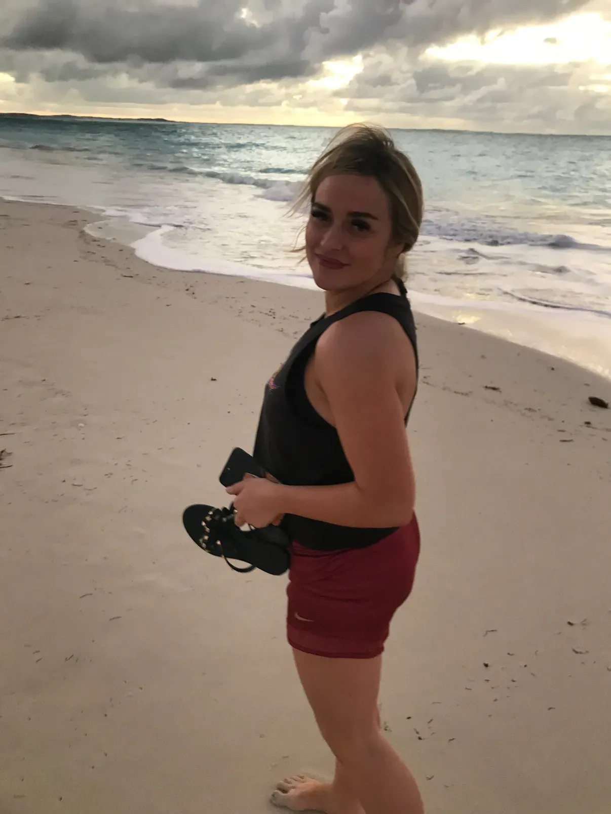 On the beach at sunset with a camera, surf and dramatic clouds behind